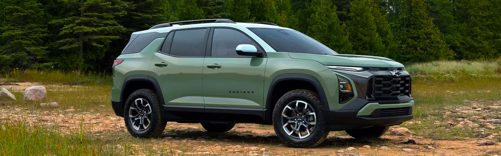 2026 Green Chevrolet Equinox compact SUV parked on a forest trail, highlighting off-road styling, rugged tires, and modern crossover design.
