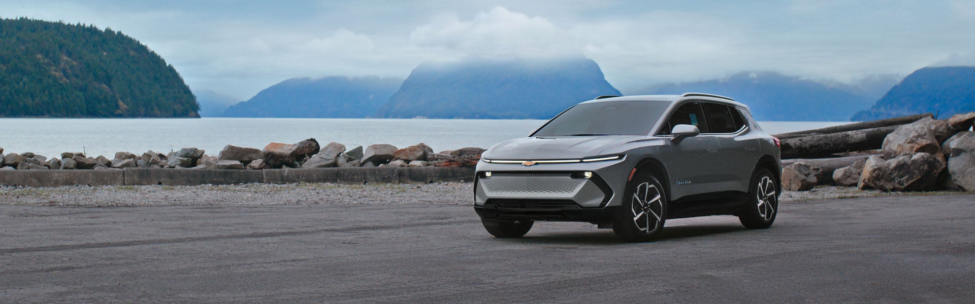 A 2026 Chevrolet Equinox EV parked near a serene body of water, showcasing its sleek design and electric features.